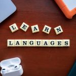 Flat lay of language learning materials with gadgets promoting education.